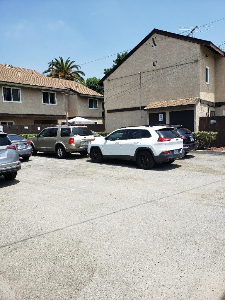 a parking lot filled with cars in front of a building